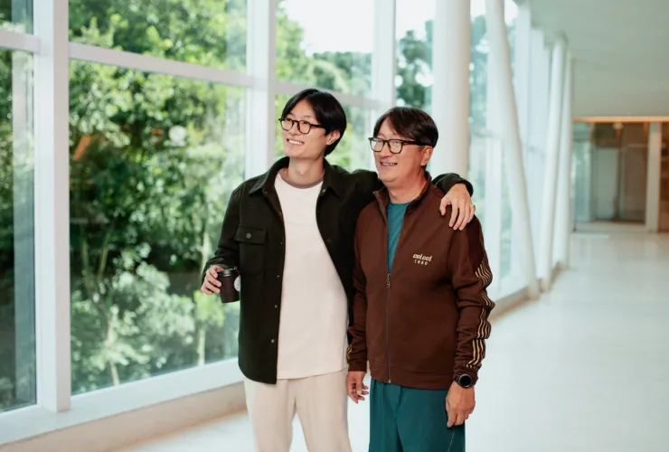 Pai e filho sorrindo em frente a uma picape Rampage Big Horn, promovendo a campanha de Dia dos Pais 2025 no ParkShoppingBarigüi.