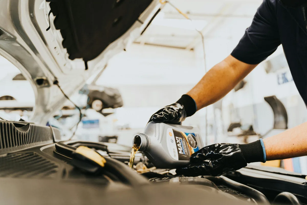 Mecânico verificando o nível de óleo do motor em oficina automotiva para garantir o uso de lubrificante correto