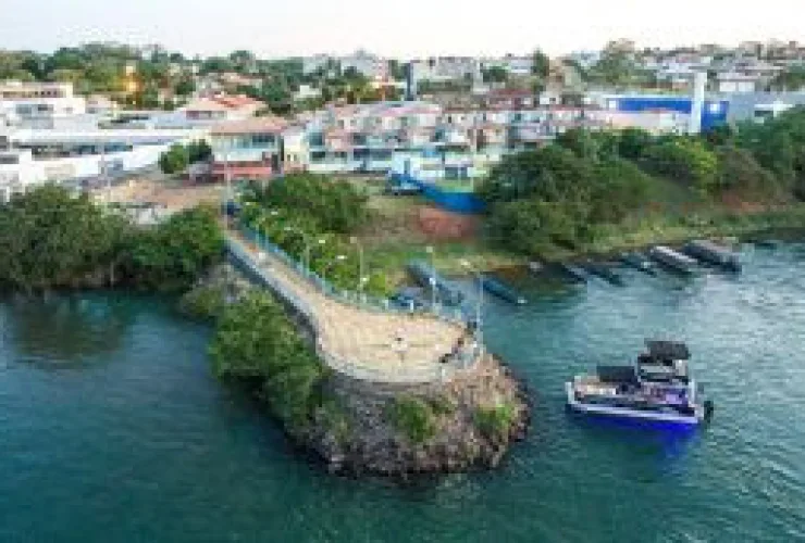 Barcos ancorados em marina no Rio Paraná, com turistas desfrutando o pôr do sol em Porto Rico (PR)