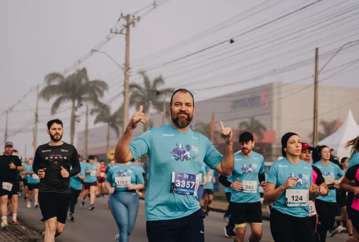 Corredores vestidos de azul participando da Corrida do Bem Eco – Blue Run em Pinhais, em contato com a natureza.