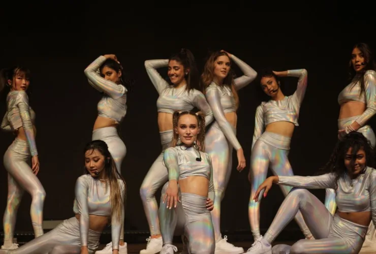 Integrantes do Now United no palco com coreografia sincronizada e luzes azuis durante a turnê “Now or Never” no Teatro Positivo, em Curitiba