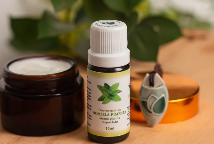 Difusor de aromaterapia com óleos essenciais sobre mesa de trabalho, auxiliando na concentração e bem-estar.