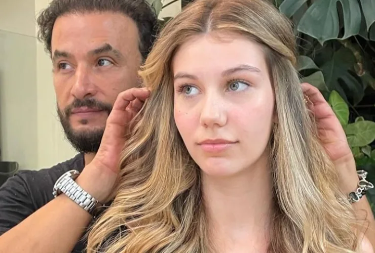 Mãos de cabeleireiro aparando pontas do cabelo para promover crescimento e saúde dos fios