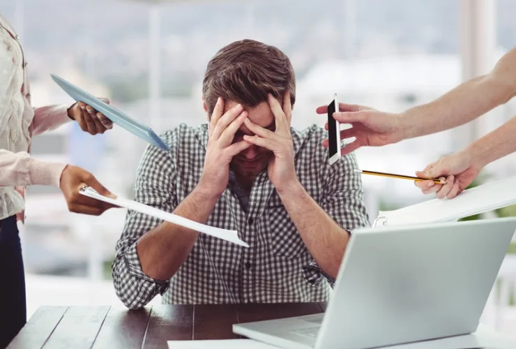 Profissional esgotado em frente ao computador, sinalizando sintomas de burnout e ansiedade.