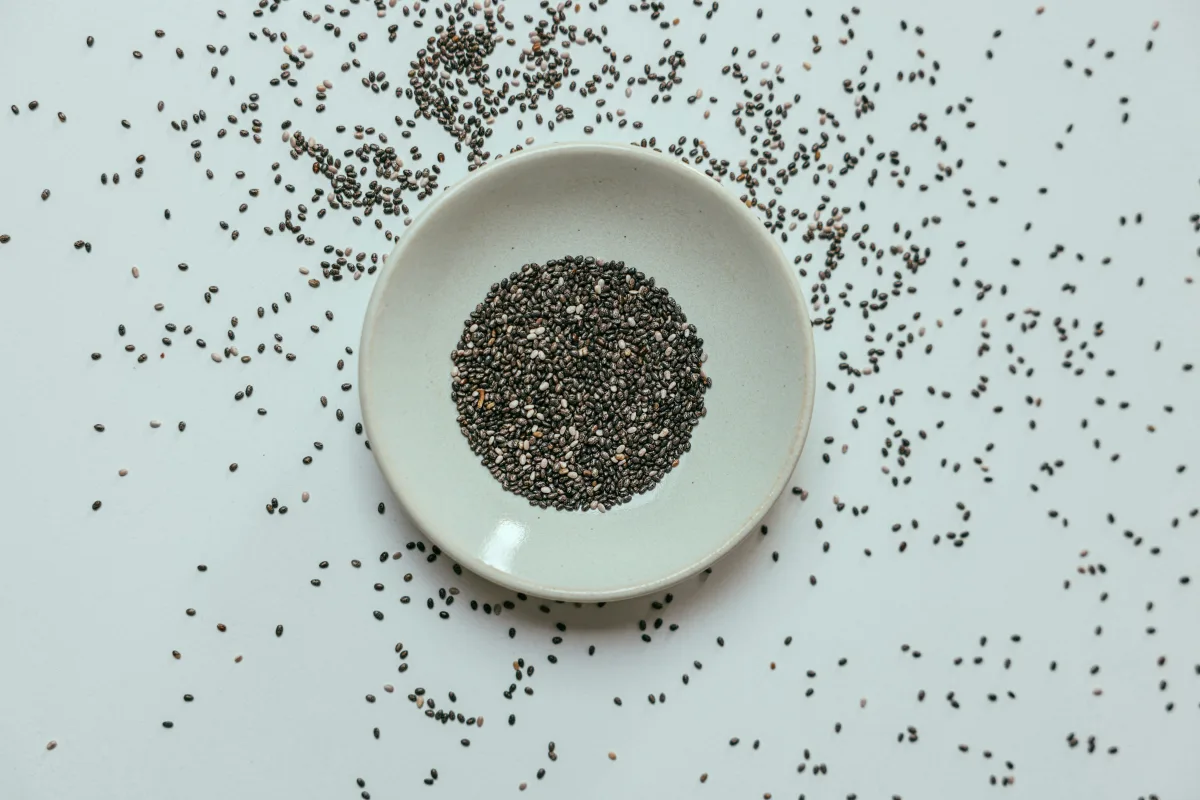 Sementes de chia, linhaça, gergelim e abóbora em potes de vidro, prontas para consumo saudável.