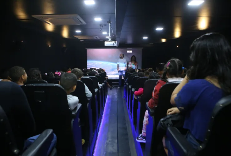 Público assistindo filme em cinema itinerante ao ar livre em Curitiba