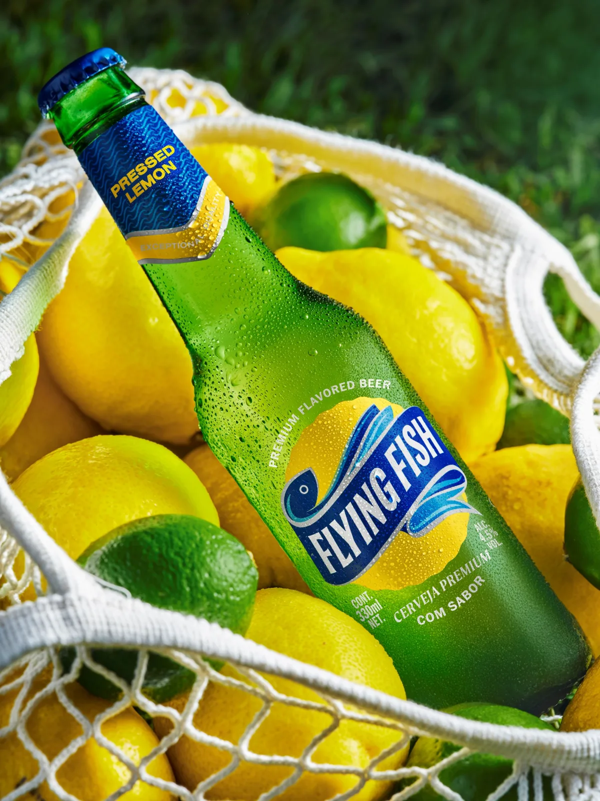 Garrafas e latas da cerveja Flying Fish mostrando embalagem com rótulo azul-claro e destaque para “limão” e “baixo amargor”.