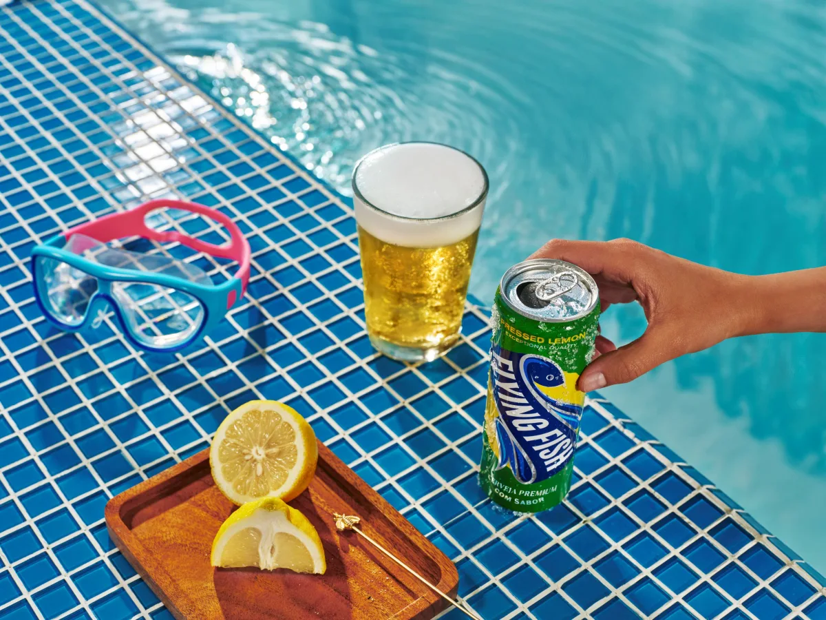 Garrafas e latas da cerveja Flying Fish mostrando embalagem com rótulo azul-claro e destaque para “limão”
