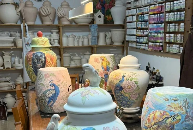 O artista Marcelo Benites pintando peça de porcelana durante workshop artístico no ateliê Almamia em Curitiba.