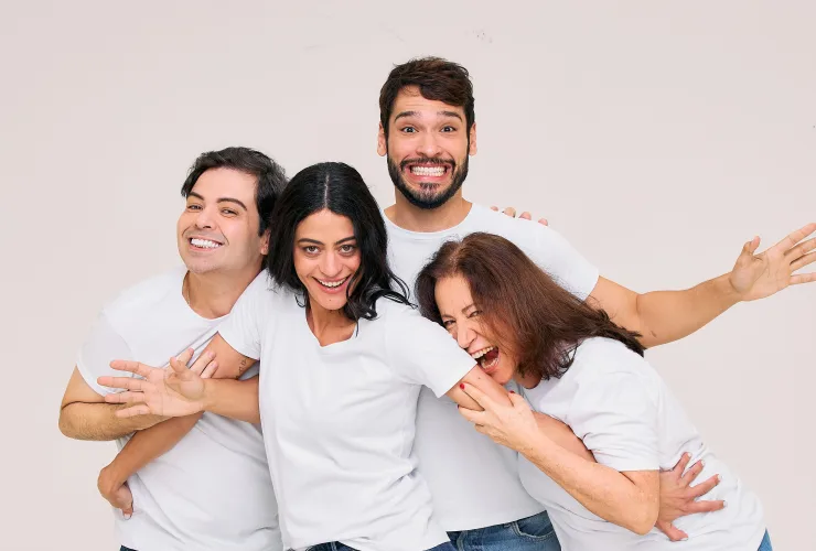 Elenco da peça “A Manhã Seguinte” no palco, em cena divertida com cenário contemporâneo e iluminação teatral.