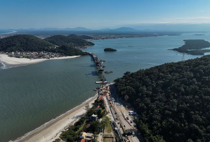 Vista aérea da Ponte de Guaratuba em construção, ligando o litoral do Paraná e destacando-se pela estrutura moderna sobre o mar.