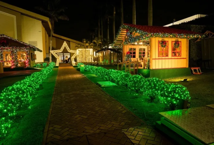 Cenário iluminado inspirado na antiga Belém, com personagens vivos e decoração natalina