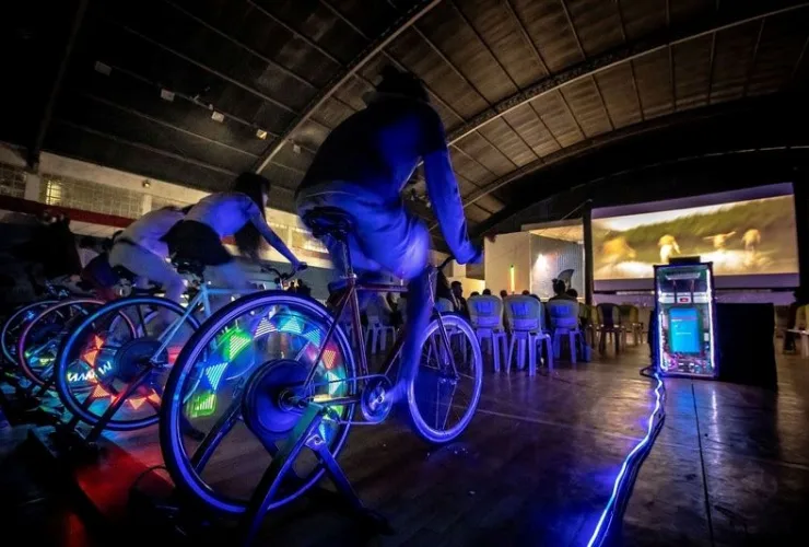 Pessoas pedalando para gerar energia no BikeCine