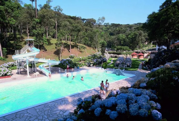 Famílias e crianças brincando em área verde da Estância Ouro Fino durante atividades de Carnaval.