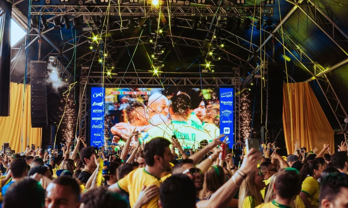 Festival Ginga em Curitiba com palco de shows e público assistindo transmissões da Copa do Mundo