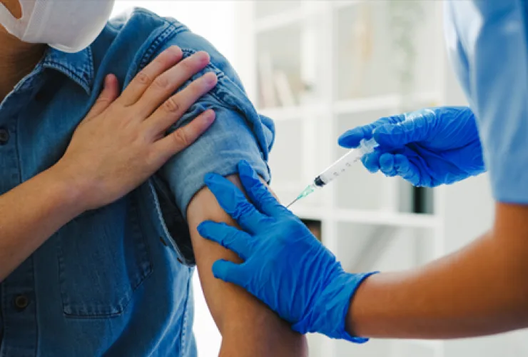 Criança recebendo vacina contra gripe em posto de saúde durante campanha de imunização no outono