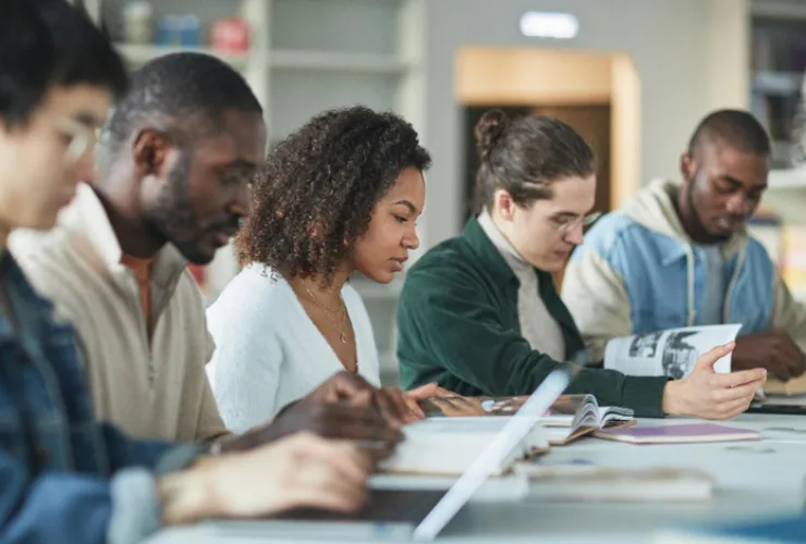 Adulto estudando inglês com notebook e caderno em ambiente doméstico focado no aprendizado
