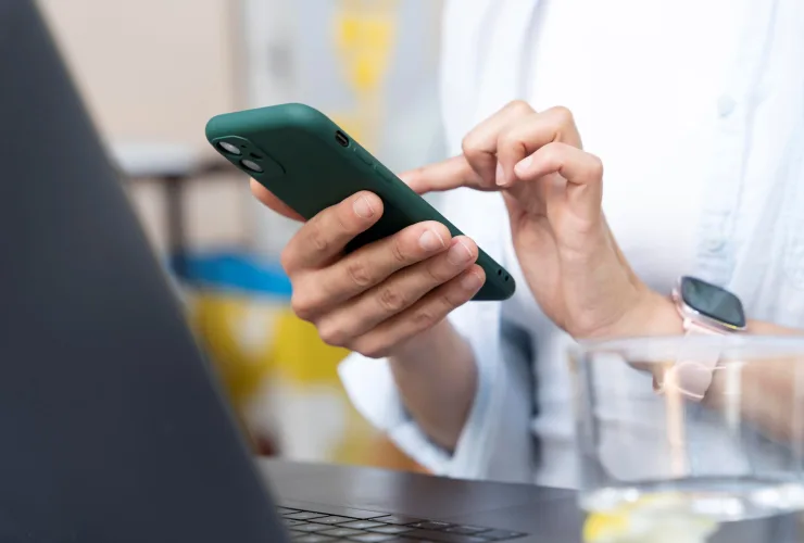 Paciente agendando consulta médica pelo WhatsApp do Hospital IPO usando smartphone
