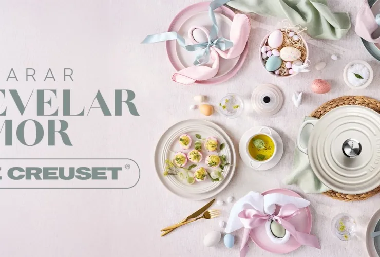 Utensílios coloridos da Le Creuset com mesa posta de Páscoa e pratos preparados para celebração
