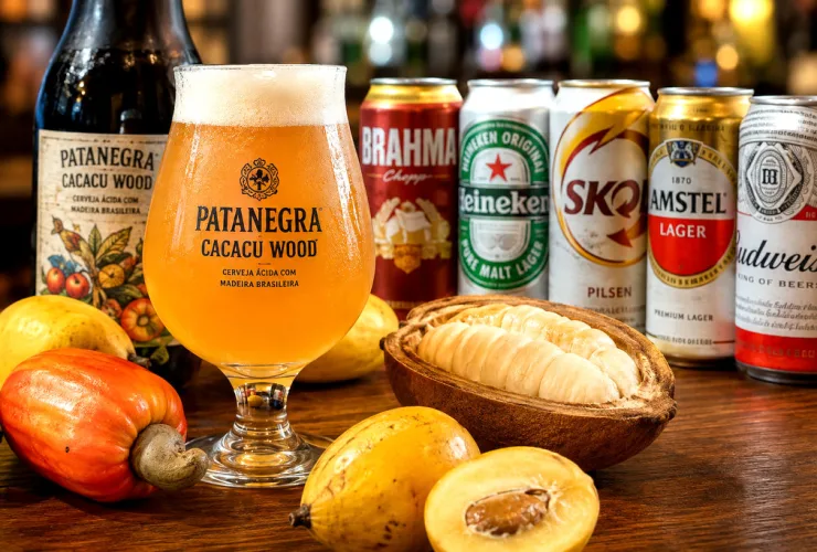 Cerveja artesanal paranaense em copo de degustação ao lado de latas de marcas populares brasileiras