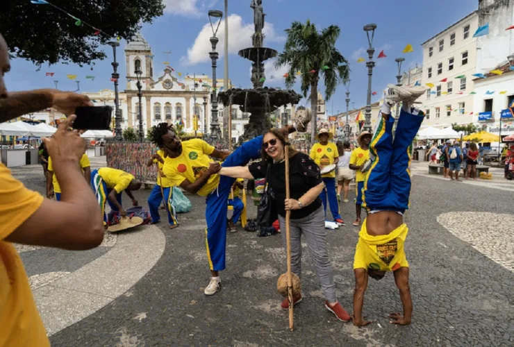 Turista participa de apresentação de capoeira em Salvador durante viagem ao Brasil