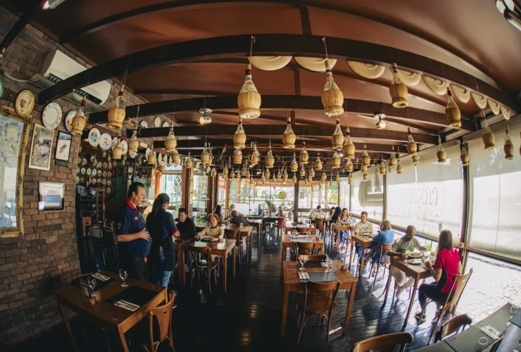 Salão da Cantina do Délio, em Curitiba, com garrafas penduradas no teto