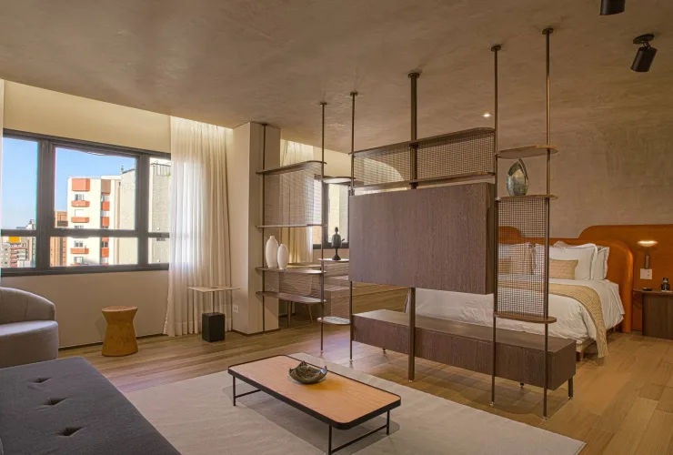 Suíte Qoya do Qoya Hotel Curitiba, com cama king-size, sofá e decoração contemporânea