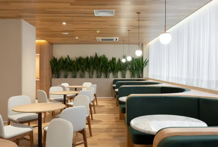 Salão do restaurante Koré, no Qoya Hotel Curitiba, com cabines e mesas com cadeiras