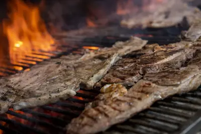 Churrasco com carnes grelhando na brasa com fogo ao fundo