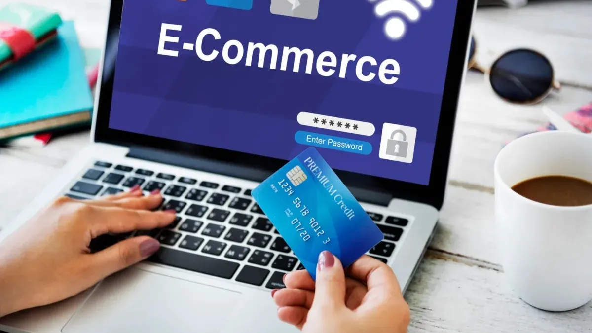Pessoa segurando cartão de crédito azul e digitando em notebook com tela mostrando login em e-commerce